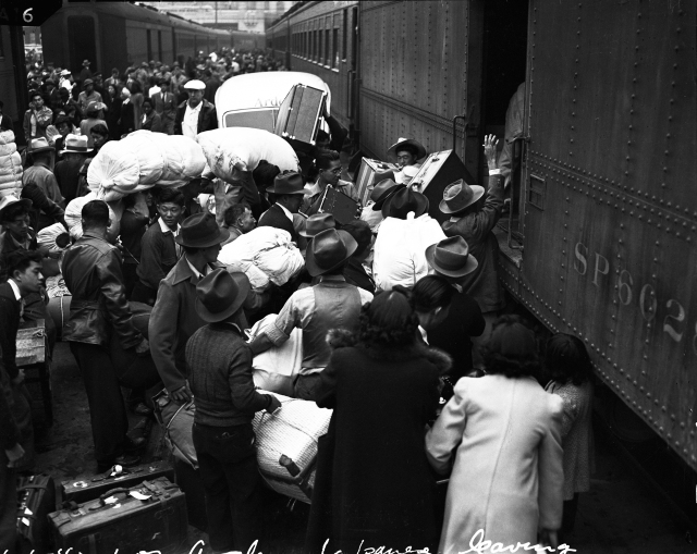 “Evacuees” in Los Angeles load their baggage onto a train that will take them to an “assembly center.” Clem Albers, 1942  